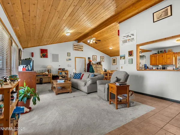 a dining room with stainless steel appliances kitchen island granite countertop a table chairs and a refrigerator