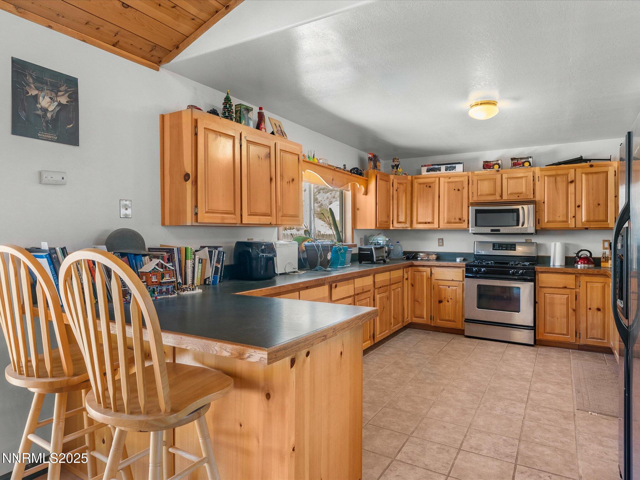 1 Cory Canyon Road Hawthorne, NV 89415 - Photo 18 of 77 a kitchen with stainless steel appliances granite countertop a stove a sink dishwasher a microwave oven with granite countertops and cabinets