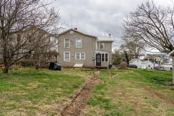a view of a yard in front of a house with large trees
