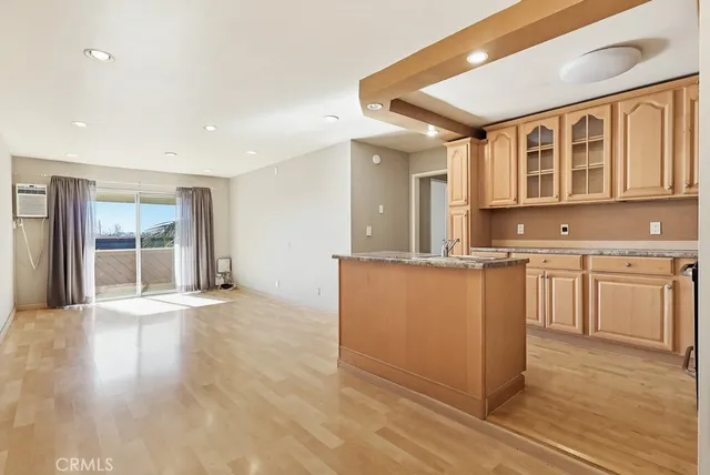 a view of kitchen with stainless steel appliances granite countertop cabinets and wooden floor