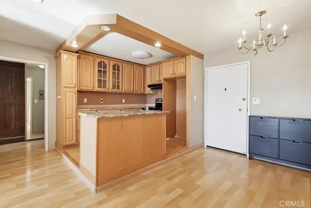 a view of kitchen with granite countertop cabinets and refrigerator