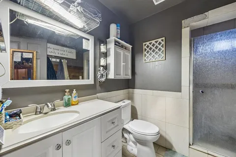 a bathroom with a sink a toilet and shower