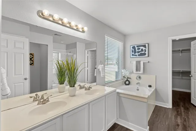 a view of an empty room with wooden floor a ceiling fan and a fireplace