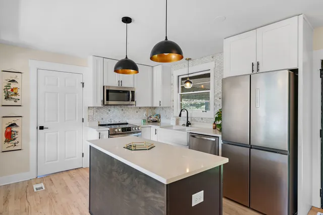 a kitchen with stainless steel appliances a stove a refrigerator and a sink