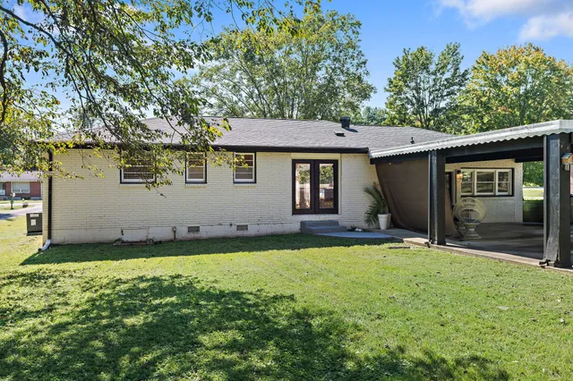 a backyard of a house with table and chairs