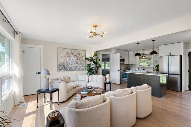 a living room with furniture a refrigerator and a fireplace
