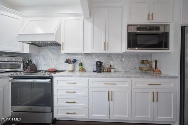 a kitchen with white cabinets and stainless steel appliances