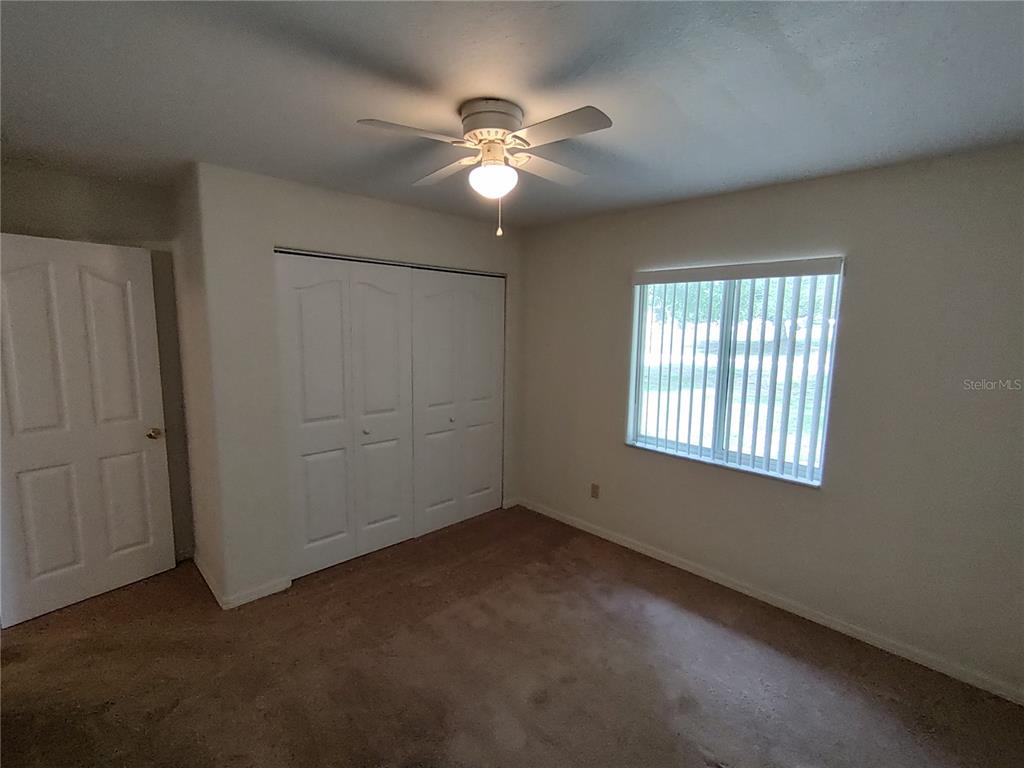 6202 Southwest 100th Loop Ocala, FL 34476 - Photo 12 of 24 an empty room with windows and fan