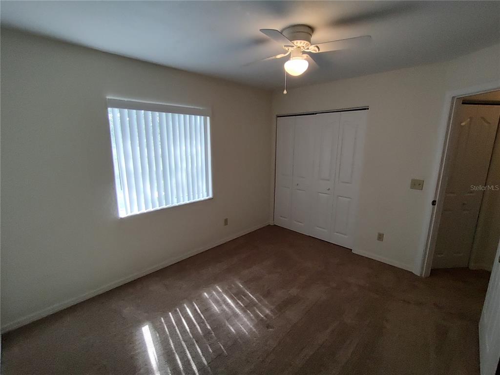 6202 Southwest 100th Loop Ocala, FL 34476 - Photo 13 of 24 an empty room with windows and fan