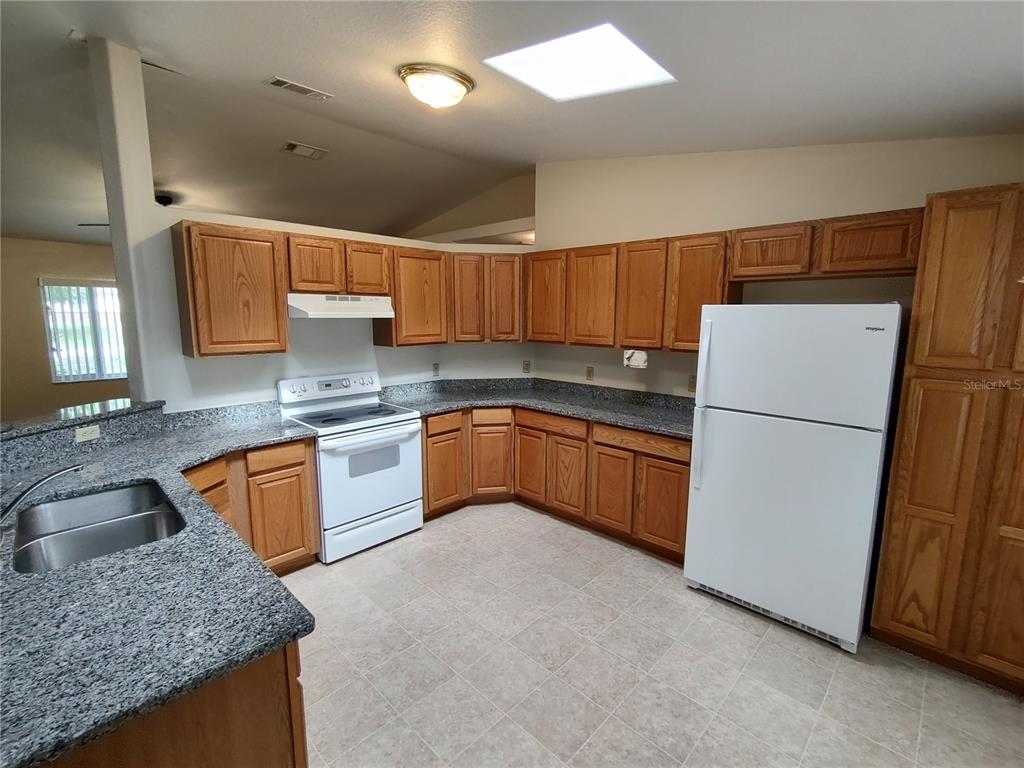 6202 Southwest 100th Loop Ocala, FL 34476 - Photo 8 of 24 a kitchen with a sink a stove a refrigerator a oven a sink and dishwasher
