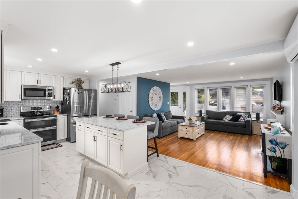 5 Albert Road Peabody, MA 01960 - Photo 8 of 39 a living room with stainless steel appliances furniture a rug kitchen view and a fireplace