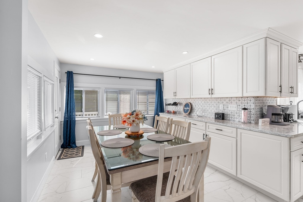 5 Albert Road Peabody, MA 01960 - Photo 9 of 39 a kitchen with a dining table chairs and white cabinets