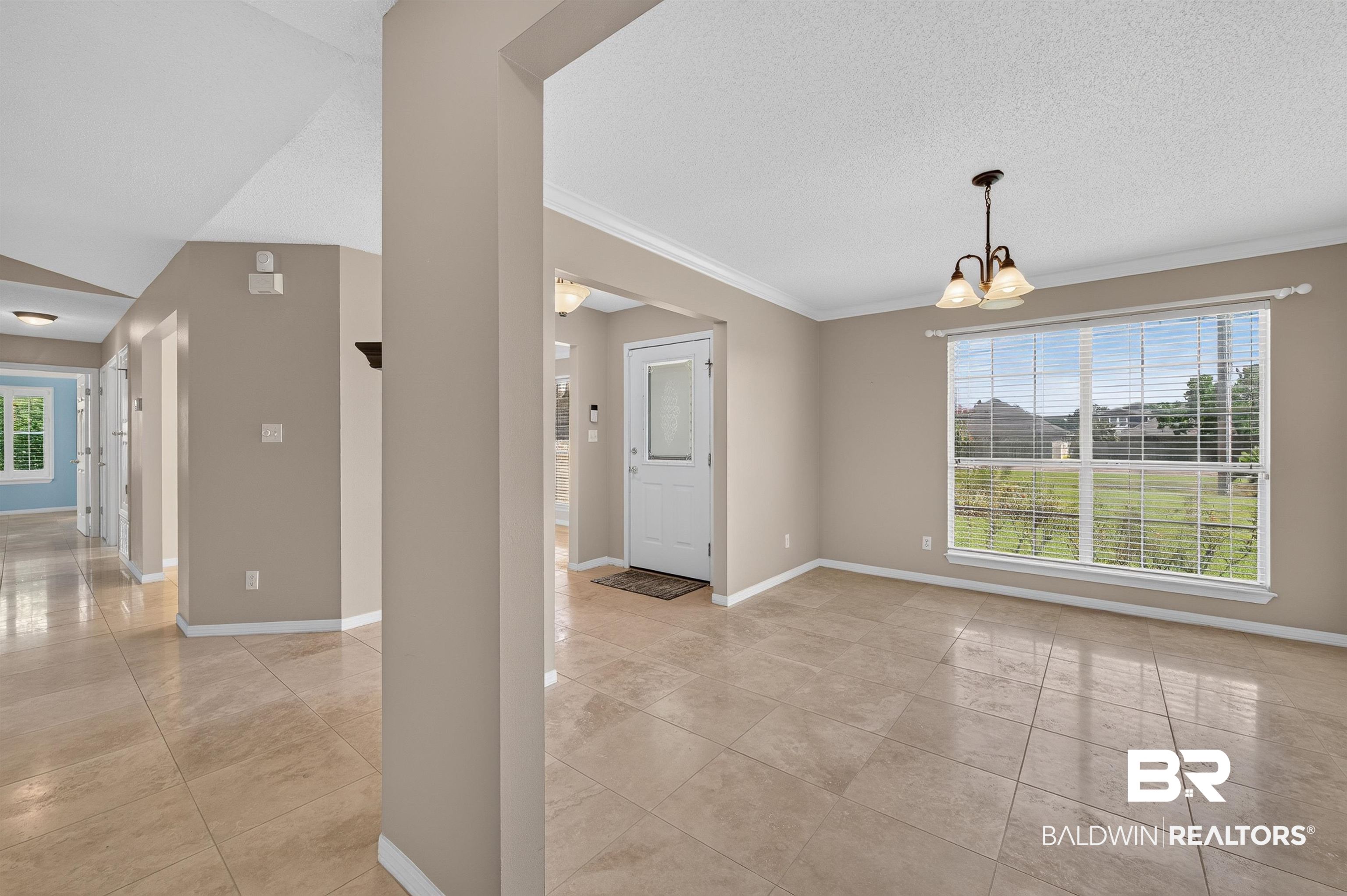 22685 County Road 12 Foley, AL 36535 - Photo 37 of 89 Neutral-toned tile flooring extends through this open interior, featuring a prominent window with a chandelier fixture