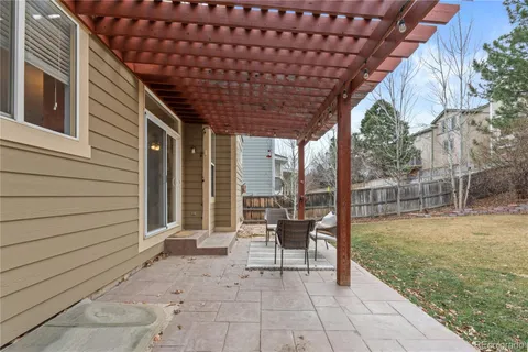 a patio with glass top table and chairs