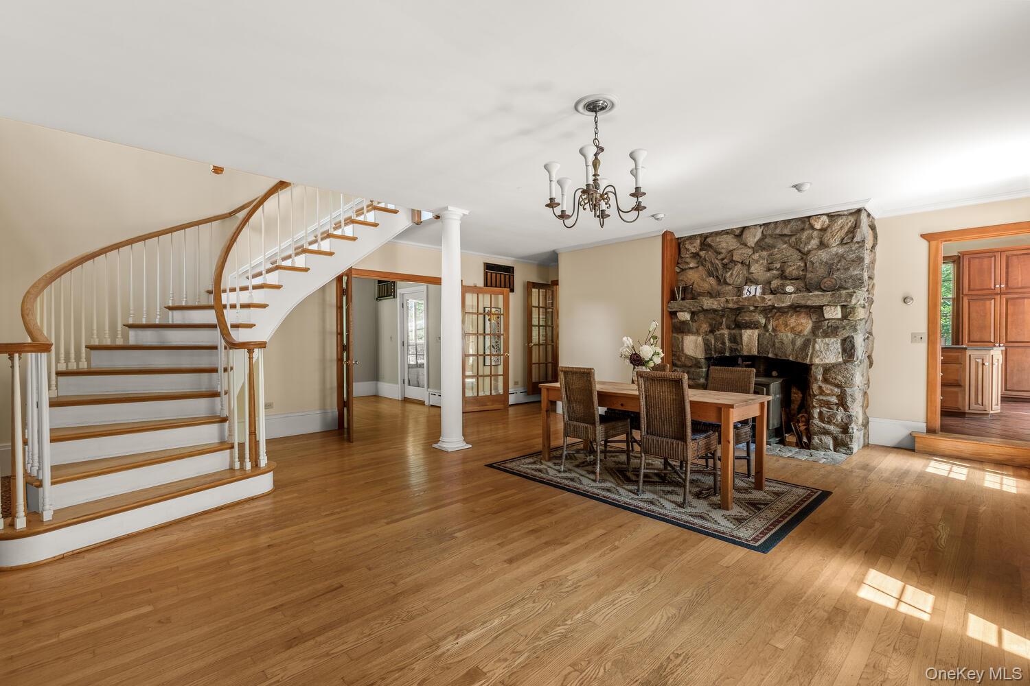 Great room w dining area, wood floors, staircase and a fireplace with wb incert