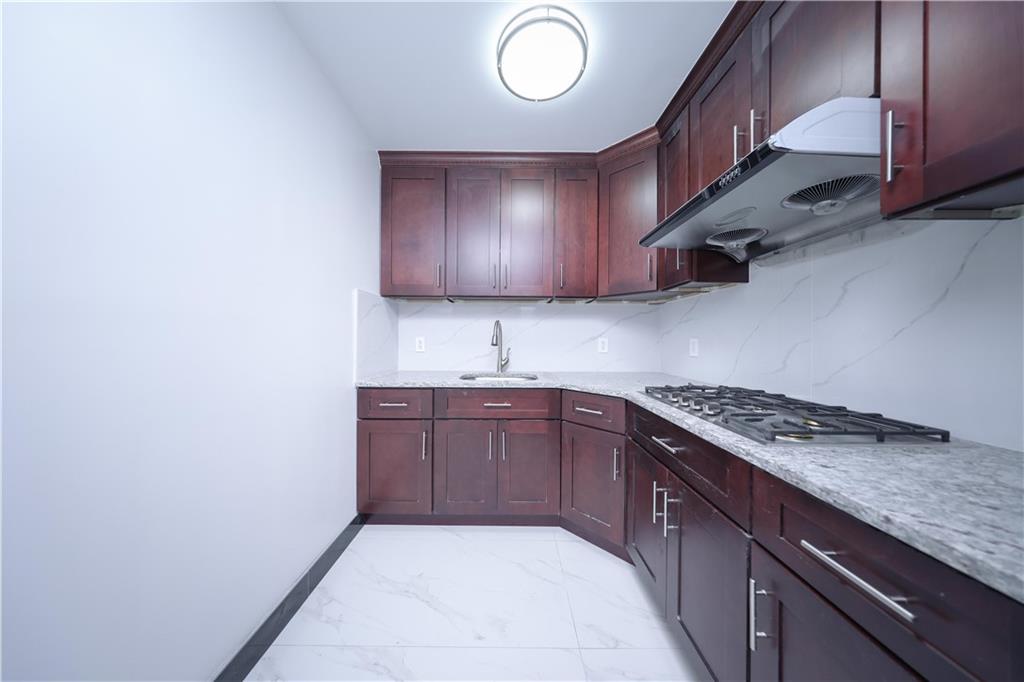 2837 West 19th Street, Unit 3A Brooklyn, NY 11224 - Photo 9 of 21 a kitchen with granite countertop a sink a stove and cabinets