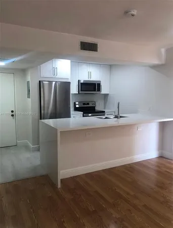 a kitchen with stainless steel appliances a refrigerator and a stove top oven