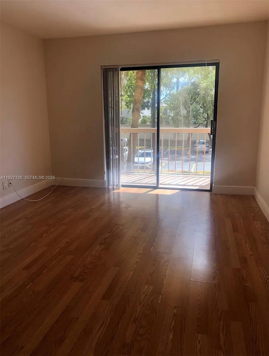 8180 Geneva Court, Unit 227 Miami, FL 33166 - Photo 5 of 11 a view of an empty room with wooden floor and a window
