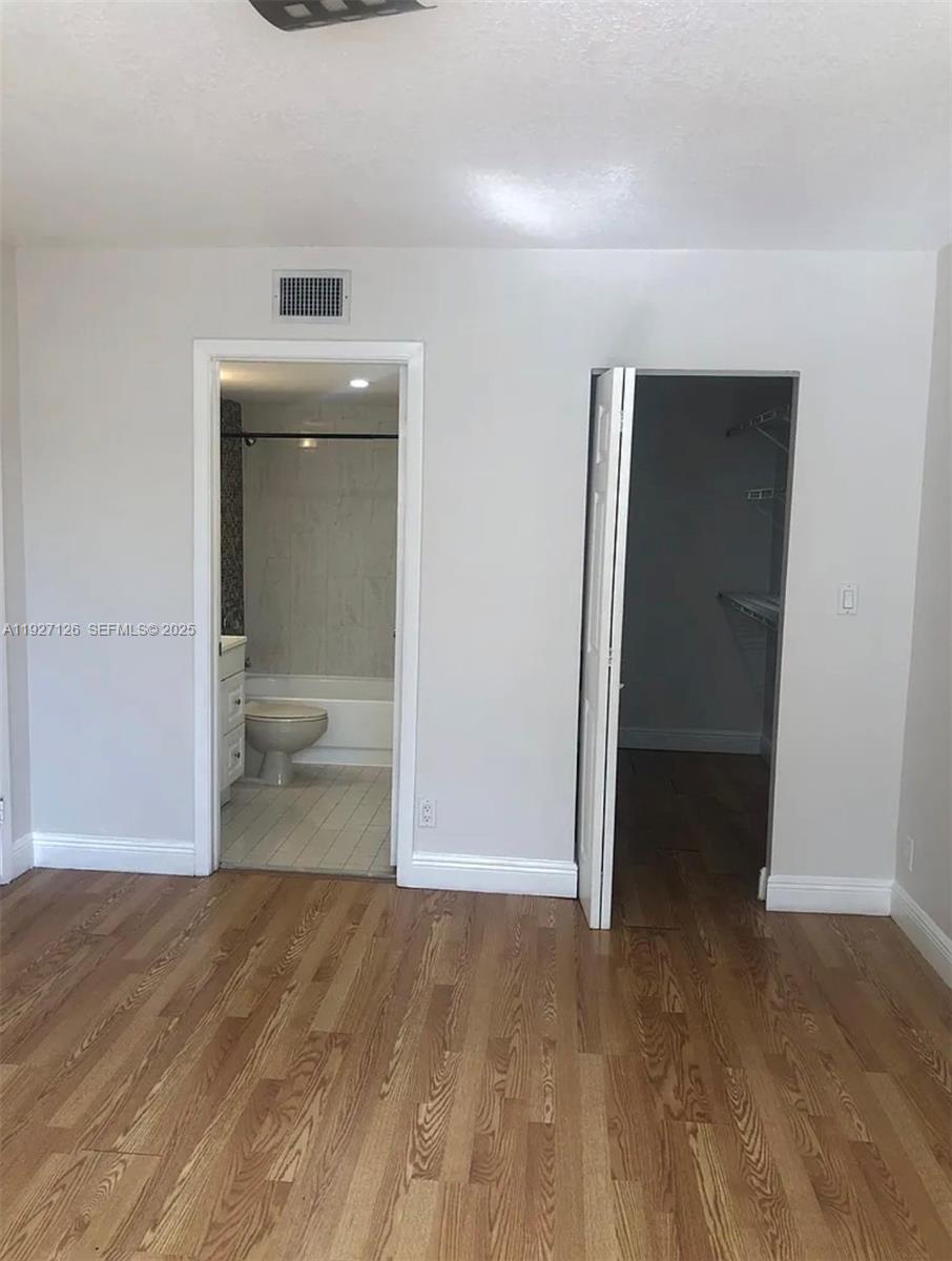 8180 Geneva Court, Unit 227 Miami, FL 33166 - Photo 6 of 11 a view of a room with wooden floor and bathroom view