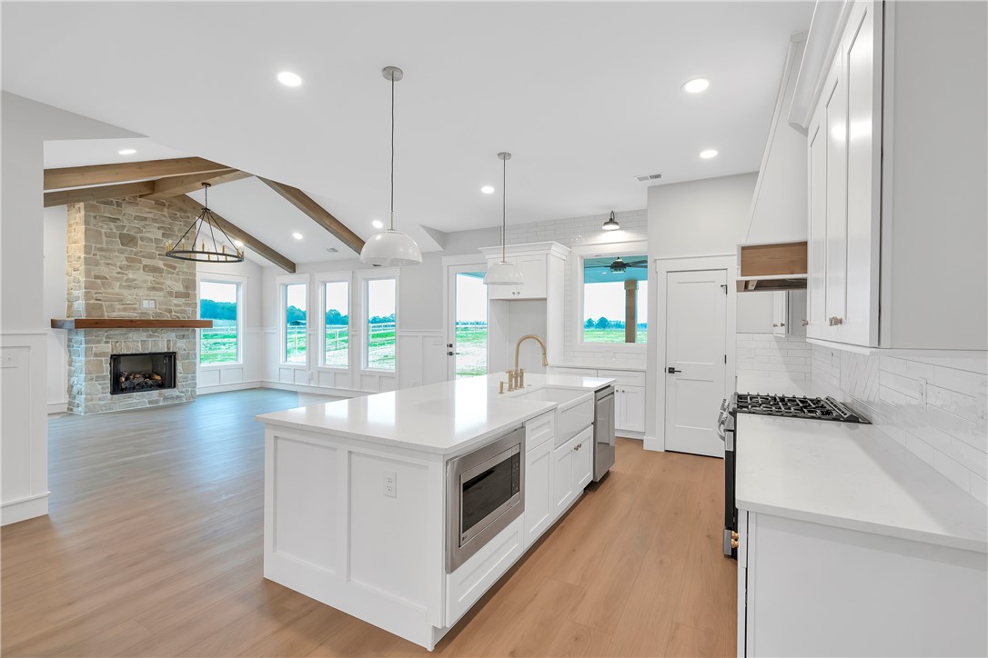 4554 Flat Rock Road Iva, SC 29655 - Photo 12 of 32 An open concept living area boasts a kitchen island with sink and microwave, all flowing into a comfortable living room with a fireplace.
