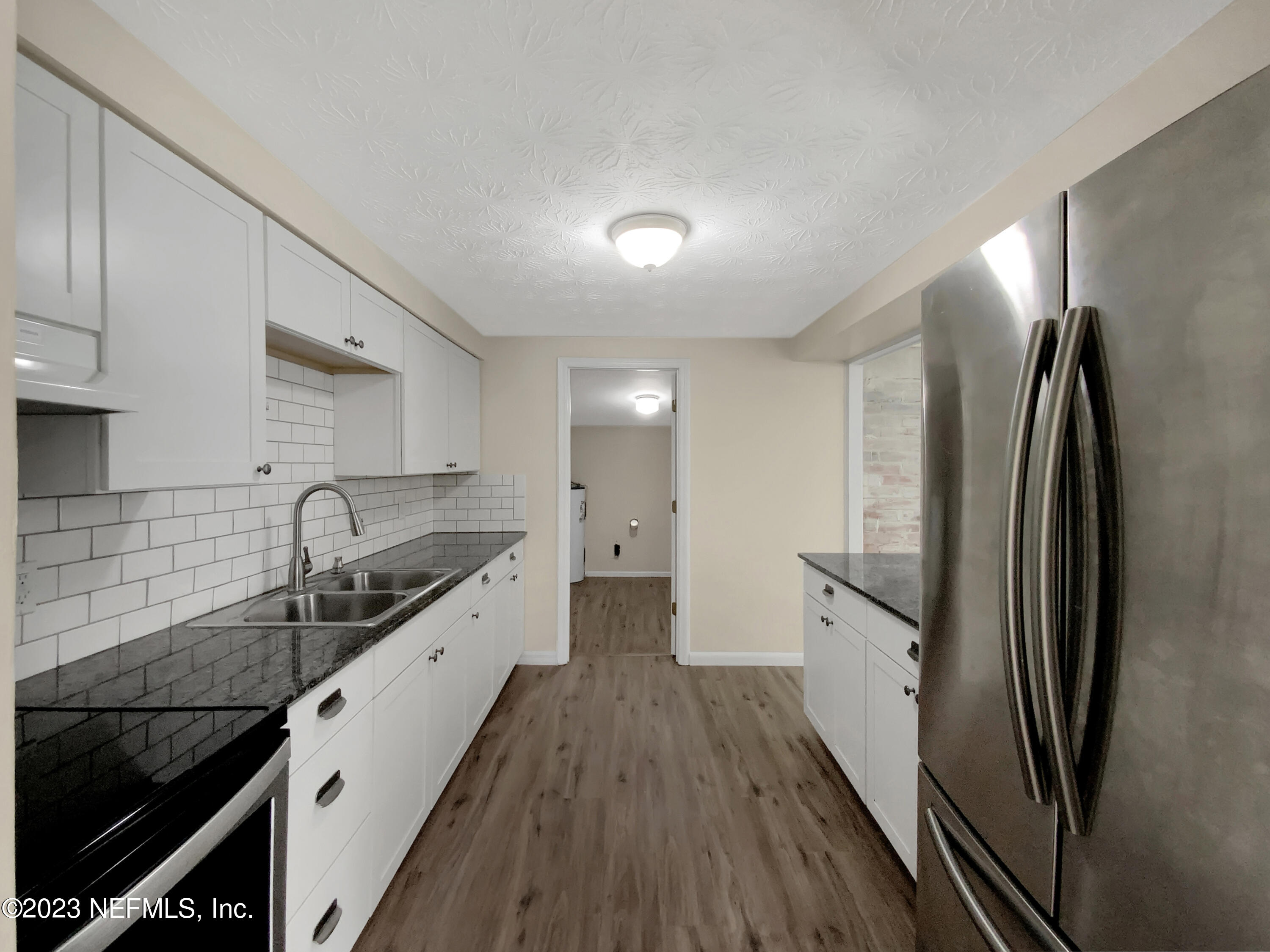413 Sigsbee Road Orange Park, FL 32073 - Photo 4 of 18 a kitchen with granite countertop a refrigerator stove and sink
