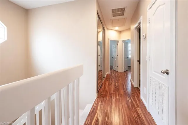 a view of a hallway with wooden floor and staircase