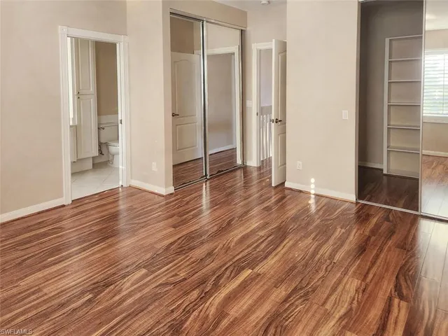 a view of a hallway with wooden floor and entryway