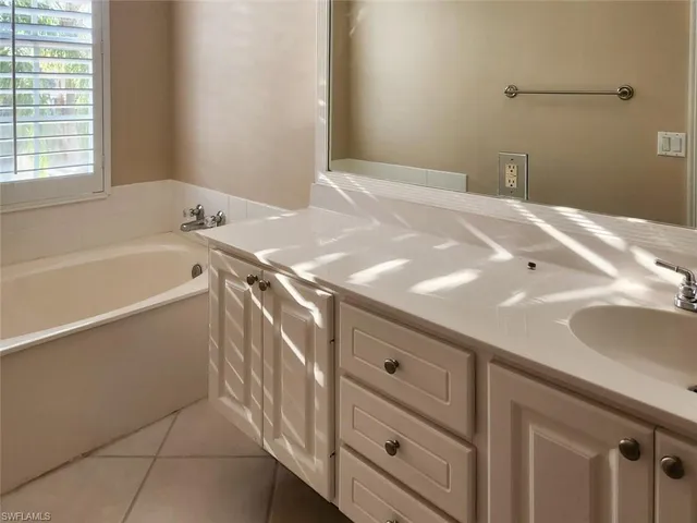 a bathroom with a tub sink and mirror