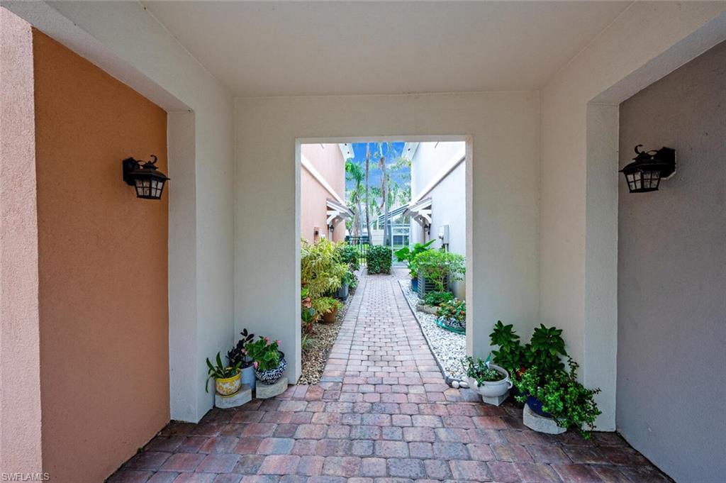 5417 Cove Circle, Unit 112 Naples, FL 34119 - Photo 2 of 37 a view of a entryway with flower pots