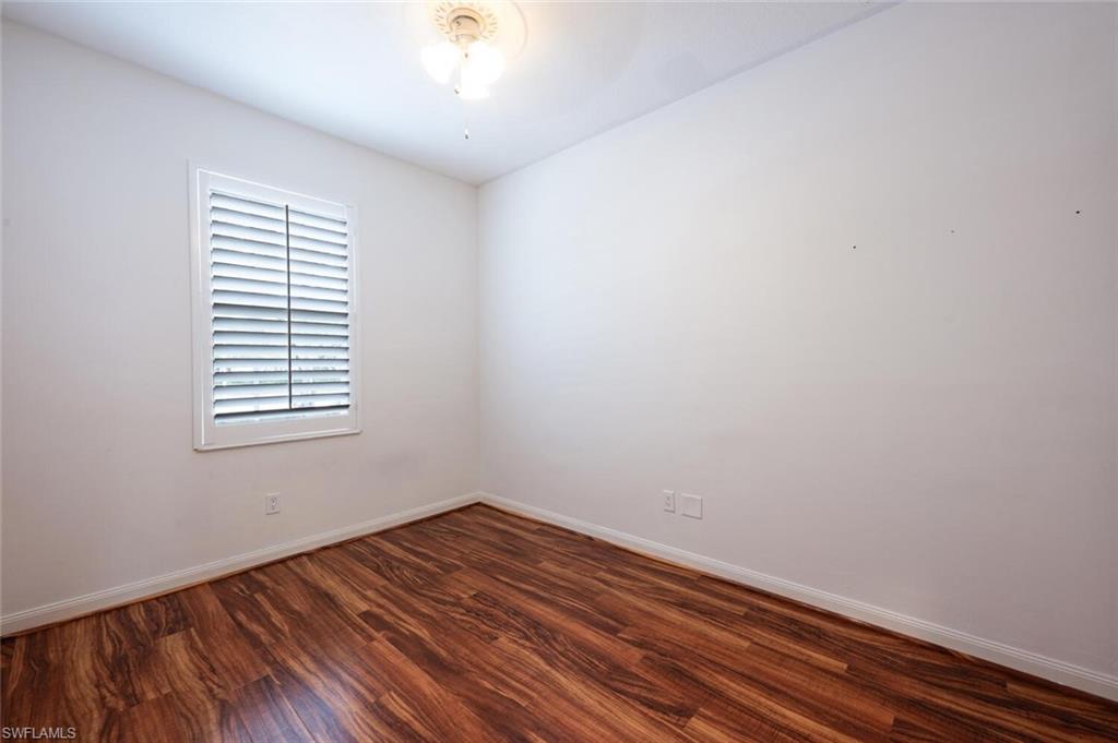 5417 Cove Circle, Unit 112 Naples, FL 34119 - Photo 25 of 37 wooden floor in an empty room with a window