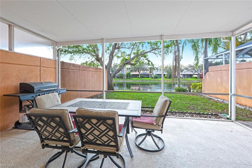 5417 Cove Circle, Unit 112 Naples, FL 34119 - Photo 30 of 37 a table and chairs with the view of garden in the back