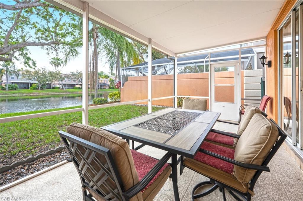 5417 Cove Circle, Unit 112 Naples, FL 34119 - Photo 31 of 37 a view of a patio with a table chairs and a backyard