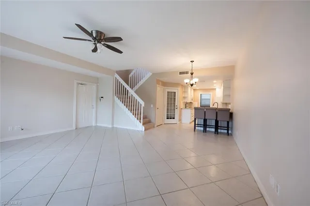 a view of a livingroom with a ceiling fan and staircase
