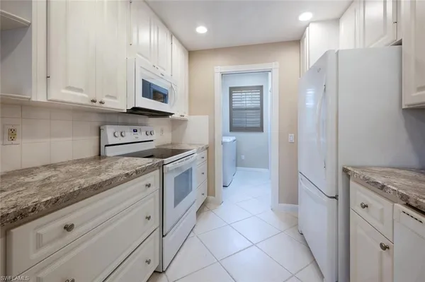 a kitchen with stainless steel appliances granite countertop a refrigerator and a stove