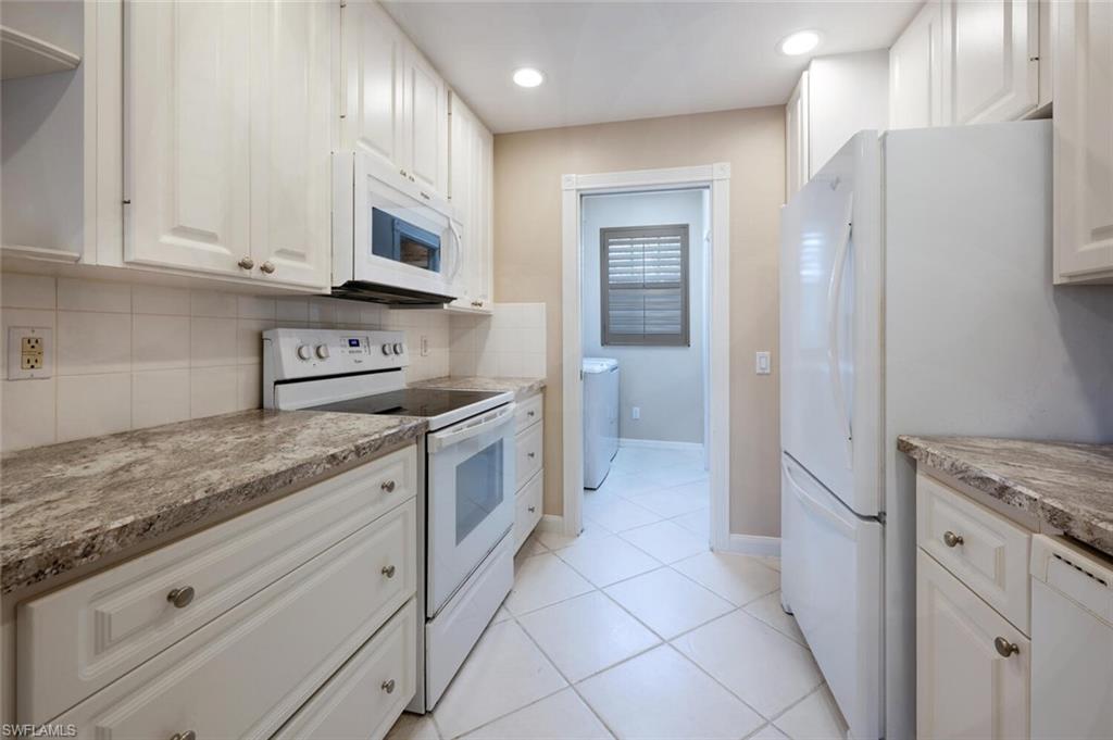 5417 Cove Circle, Unit 112 Naples, FL 34119 - Photo 9 of 37 a kitchen with stainless steel appliances granite countertop a refrigerator and a stove