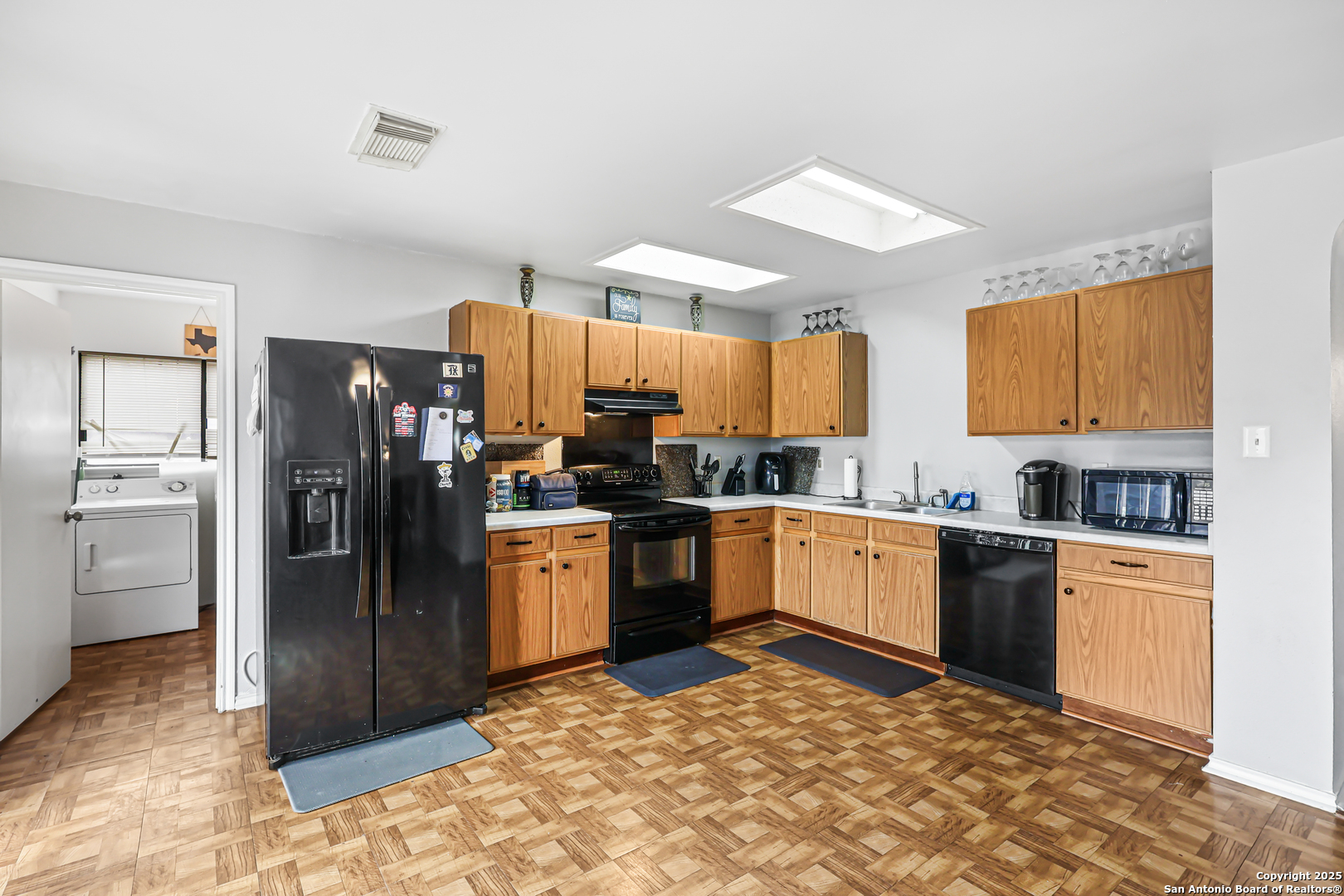 7234 Raintree Forest San Antonio, TX 78233 - Photo 9 of 23 a kitchen with a refrigerator sink and wooden cabinets