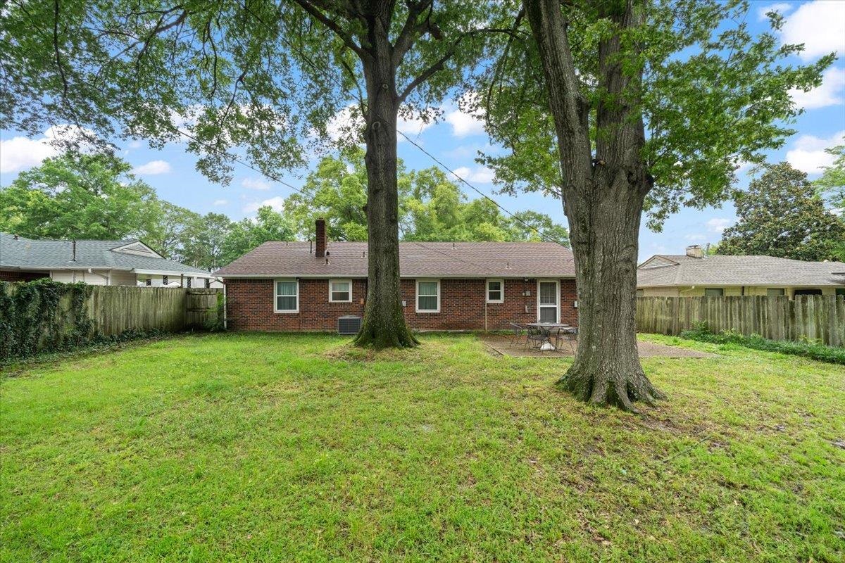 4841 Dee Road Memphis, TN 38117 - Photo 25 of 28 Rear view of property with brick siding, a fenced backyard, a patio, and a chimney