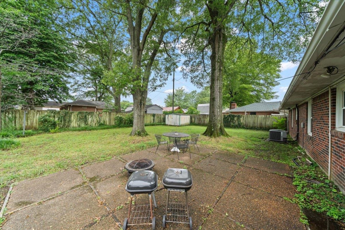 4841 Dee Road Memphis, TN 38117 - Photo 27 of 28 Fenced backyard with a shed, a patio, and a fire pit
