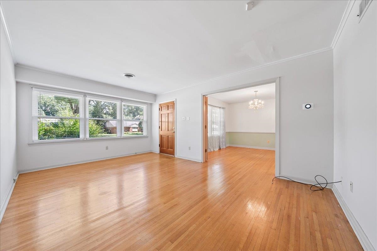 4841 Dee Road Memphis, TN 38117 - Photo 7 of 28 Spare room with plenty of natural light, a chandelier, light wood-type flooring, and ornamental molding