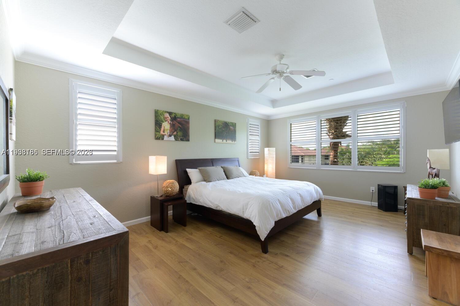 250 Southwest Walking Path, Unit 250 Stuart, FL 34997 - Photo 21 of 29 a bedroom with a bed and wooden floor