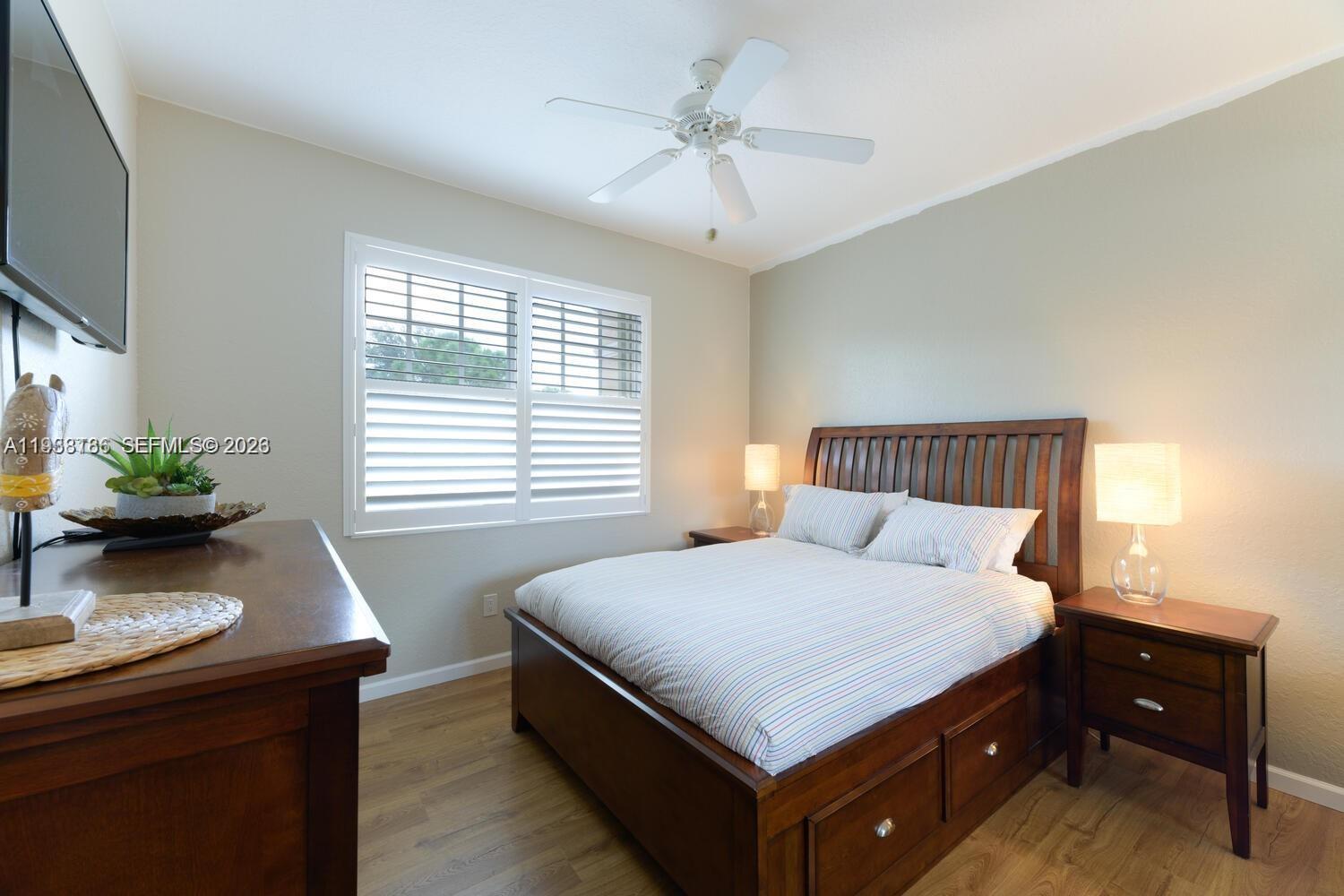 250 Southwest Walking Path, Unit 250 Stuart, FL 34997 - Photo 27 of 29 a bedroom with a bed and a potted plant