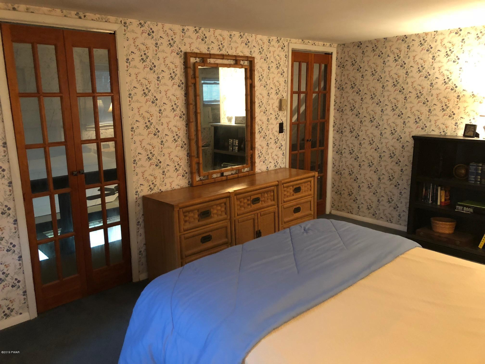 176 Heather Hill Road Dingmans Ferry, PA 18328 - Photo 21 of 32 a bedroom with a bed and a flat screen tv