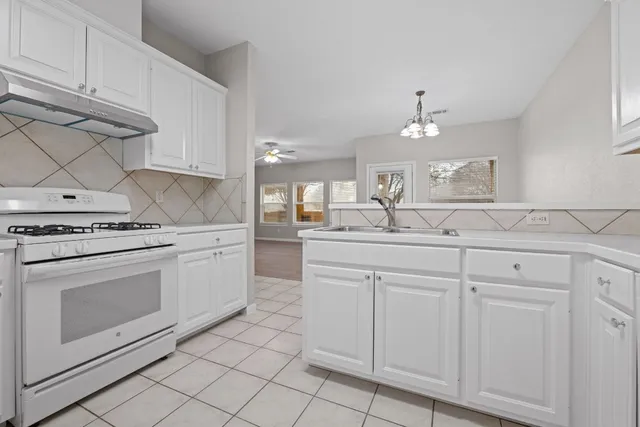 a kitchen with white cabinets and white appliances