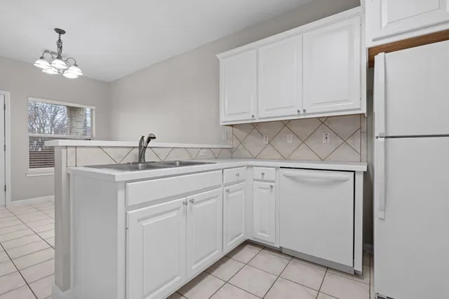 a kitchen with white cabinets and sink