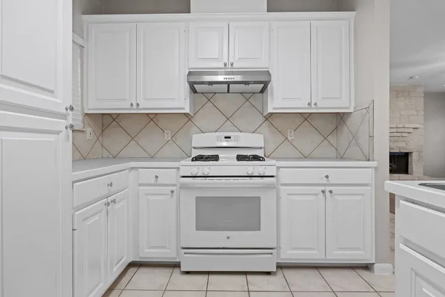 a kitchen with white cabinets and white appliances