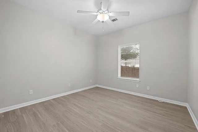wooden floor in an empty room with a window