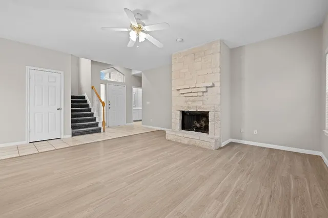 wooden floor fireplace and windows in an empty room