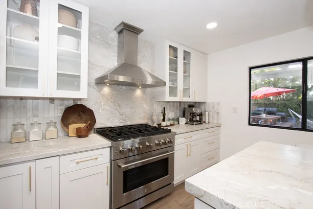 a kitchen with stainless steel appliances granite countertop a stove a sink and a microwave