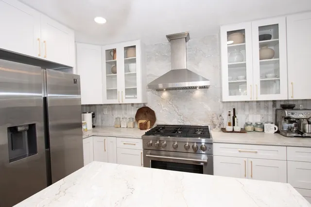 a kitchen with stainless steel appliances granite countertop a stove a refrigerator and a sink