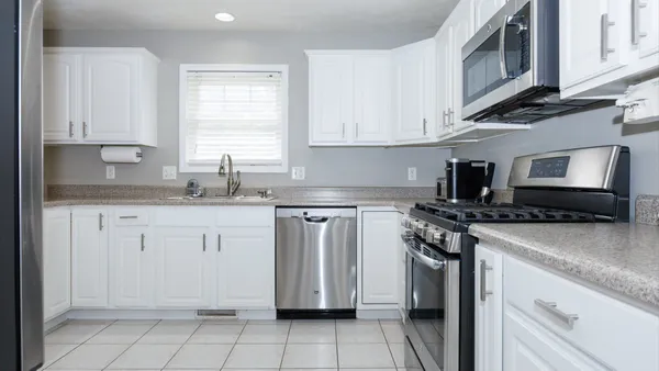 a kitchen with granite countertop white cabinets and white appliances